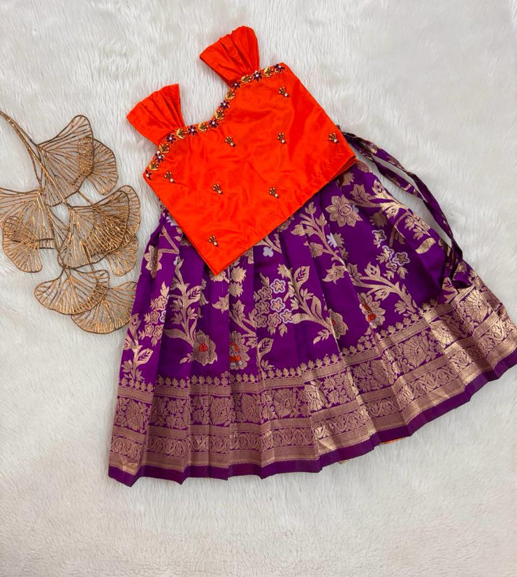 Orange top and purple skirt with gold patterns on a light gray background